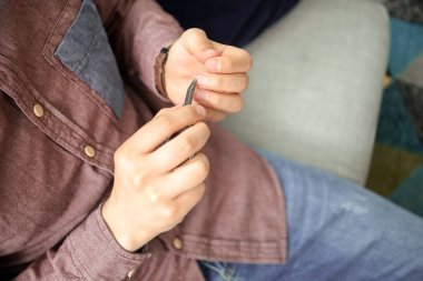 Genç Asyalı adam evde manikür yapıyor, yakın plan.