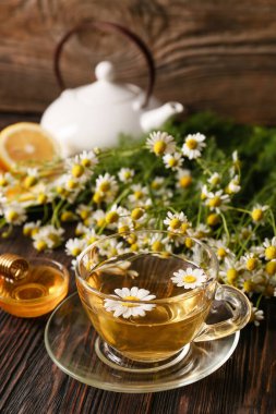 Ahşap arka planda bir fincan papatya çayı.