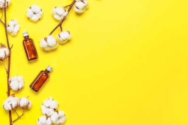 Renk arkaplanında kozmetik ürünleri olan pamuk çiçekleri