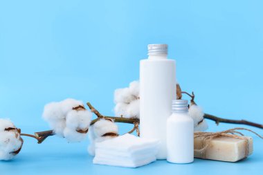 Renk arkaplanında pamuk pedleri olan kozmetikler