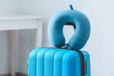 Evde bavul ve seyahat yastığı var.