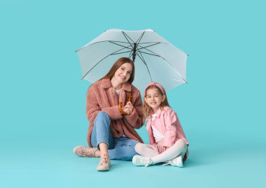 Renkli şemsiyeli anne ve küçük kızı.