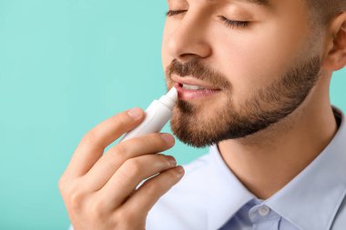 Renkli dudak merhemi kullanan yakışıklı bir genç.