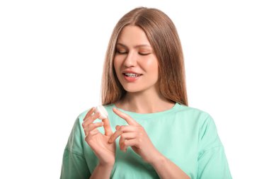 Beyaz arka planda dudak kremi olan güzel genç bir kadın.