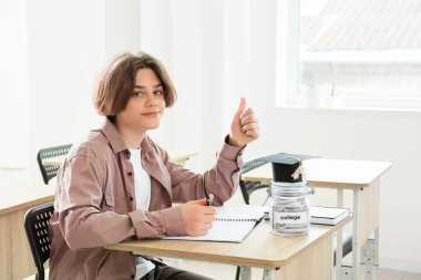 Sınıfta eğitim için birikimleri olan genç bir çocuk.