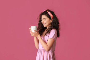 Arka planda sıcak çayı olan güzel genç bir kadın.