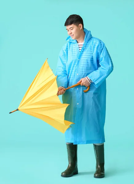 身穿雨衣 背带雨伞的年轻亚洲男子 — 图库照片