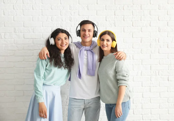 Young Friends Listening Music White Brick Background — Stock Photo, Image