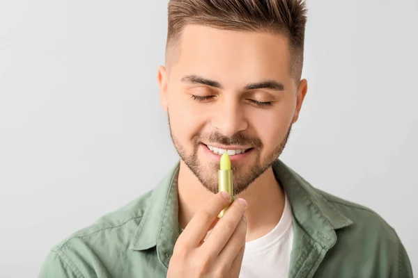 Beau Jeune Homme Avec Baume Lèvres Sur Fond Clair — Photo