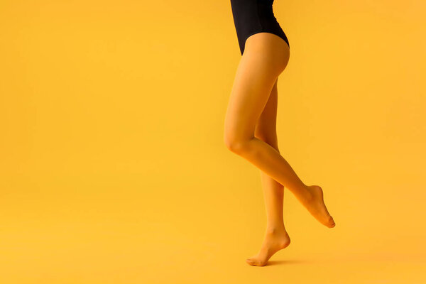 Beautiful young woman in tights on color background