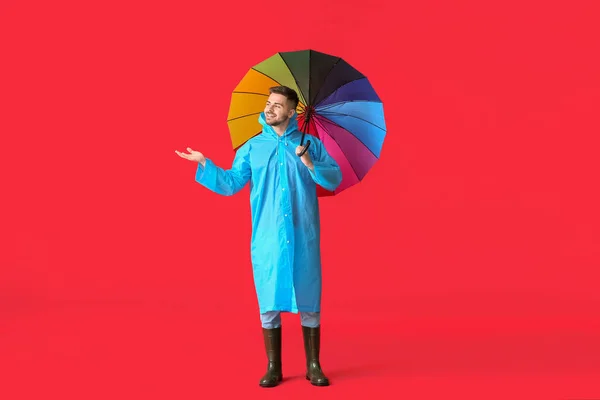 レインコートの若いです男と傘で色の背景 — ストック写真