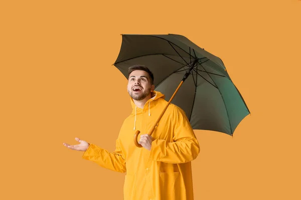 Fiatal Férfi Esőkabátban Esernyővel Színes Háttér — Stock Fotó