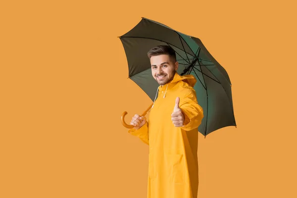 Hombre Joven Impermeable Con Paraguas Que Muestra Pulgar Hacia Arriba — Foto de Stock