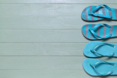 Ahşap arka planda şık parmak arası terlikler