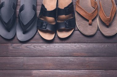 Ahşap arka planda şık parmak arası terlikler