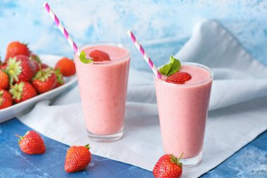 Renkli arkaplanda lezzetli çilekli smoothie bardakları