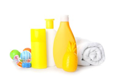 Beyaz arka planda oyuncak ve havlu olan güneş kremi.