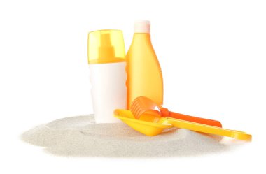 Beyaz arka planda kumsal oyuncakları olan güneş kremi.