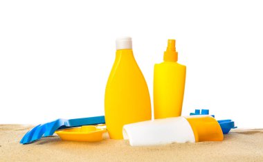 Beyaz arka planda kumsal oyuncakları olan güneş kremi.