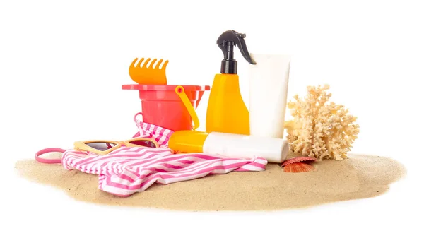 白い背景にビーチの砂のおもちゃや水着と日焼け止めクリーム — ストック写真