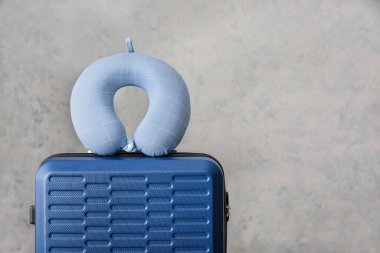 Hafif arka planda valiz ve seyahat yastığı