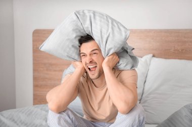 Genç adam yatak odasında uykusuzluk çekiyor.