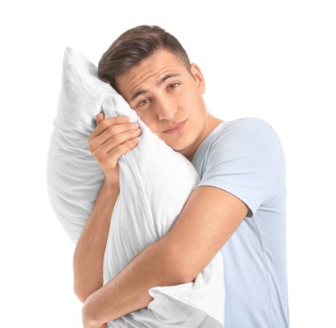 Beyaz arka planda yastığı olan yorgun bir adam. Uykusuzluk kavramı