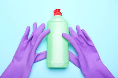 Bulaşık deterjanı ve arka planda lastik eldiven.