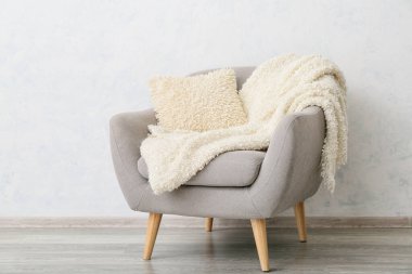 Koltuk ve yumuşak yastık odada ışık duvarının yanında.