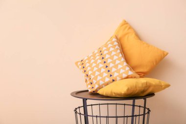 Masa ve yumuşak yastıklar odada renk duvarının yanında.