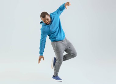 Açık arkaplanda Afrikalı Amerikalı hip-hop dansçısı.