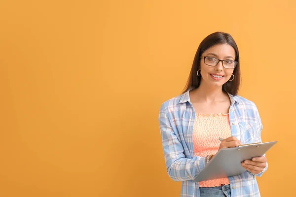 Schöne Junge Frau Mit Klemmbrett Auf Farbigem Hintergrund — Stockfoto