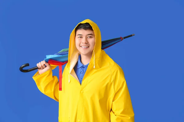 Mladý Asijský Muž Pláštěnce Deštníkem Barevném Pozadí — Stock fotografie