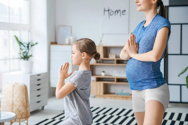 Fiatal Terhes Kislánya Otthon Jógáznak — Stock Fotó