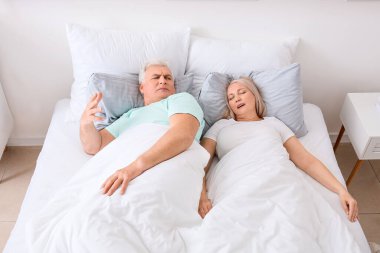 Yatakta horlayan karısıyla sinirli bir adam.