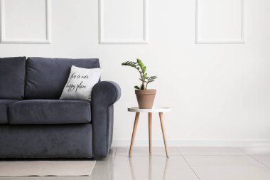 Şık bir kanepe ve odanın duvarında çiçek olan bir masa.