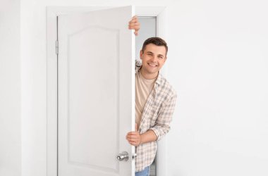 Kapıdan dışarı bakan meraklı adam.