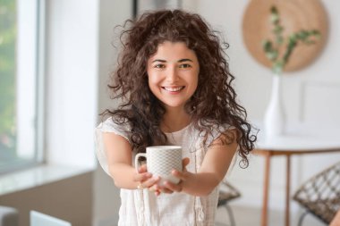 Güzel genç bayan evde sıcak çay içiyor.