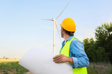 Yel değirmeni çiftliğinde elektrik üretimi için çalışan erkek mühendis.