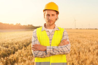 Yel değirmeni çiftliğinde elektrik üretimi için çalışan erkek mühendis.