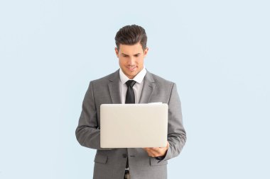 Şık takım elbiseli ve dizüstü bilgisayarı olan genç bir iş adamı.