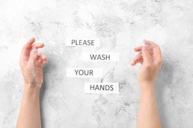 Sabun köpüğü ve mesajı olan kadın elleri lütfen ellerinizi beyaz arka planda yıkayın, üst görünüm