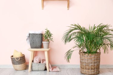 İçinde ev bitkileri, yastıklar ve kareli kumaşlar olan sepetler.