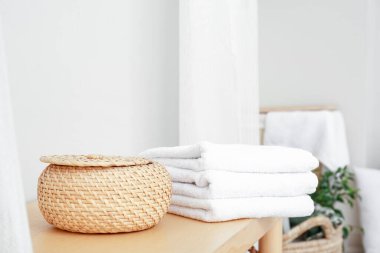 Banyodaki bankta havlularla dolu bir sepet.