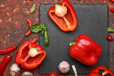 Kırmızı dolma biber, bitkiler ve baharatlar masada.