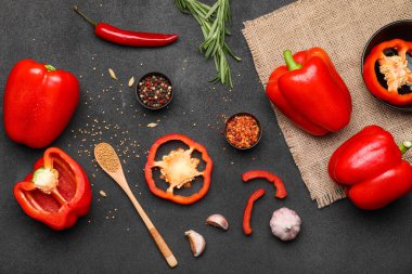 Kırmızı dolma biber, otlar ve baharatlar koyu arkaplanda