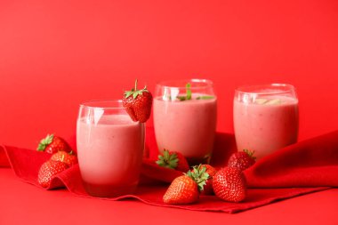 Renkli arkaplanda lezzetli çilekli smoothie bardakları