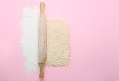 Arkaplanda pirinç ve un bulunan yuvarlanan iğne.