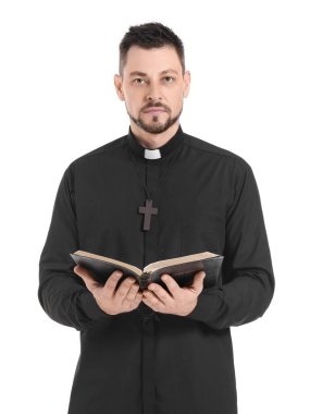Beyaz arka planda İncil 'i olan yakışıklı bir rahip.