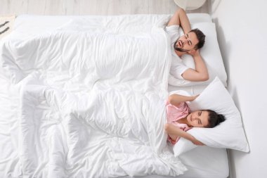 Yatakta uyuyan genç bir çift.